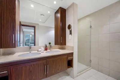 a bathroom with two sinks and a shower at Durrani Homes - Lumina Grand 3BR with Burj khalifa and Fountain Views in Dubai