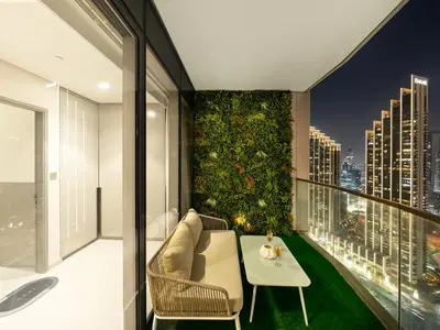a room with a green wall with a couch and a table at Grandeur 2 Bedroom Apartments I Burj Khalifa & Fountain Views I Free Parking, Gym, Pool, Wi-Fi & PS5 I by Skyline Serenity in Dubai