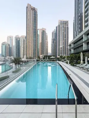 a large swimming pool in a city with tall buildings at Grandeur 2 Bedroom Apartments I Burj Khalifa & Fountain Views I Free Parking, Gym, Pool, Wi-Fi & PS5 I by Skyline Serenity in Dubai