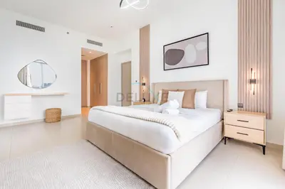 a white bedroom with a large bed and a dresser at Magnificent 2BR Apartment at Act One Act Two Tower 2 in Downtown Dubai by Deluxe Holiday Homes in Dubai