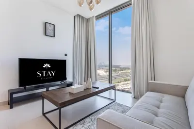 a living room with a couch and a tv at STAY BY LATINEM Luxury 1BR Holiday Home CV B1311 near Burj Khalifa in Dubai
