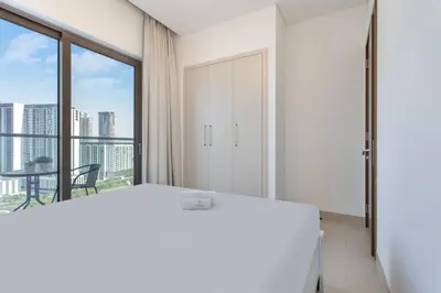 a white bedroom with a bed and a window at STAY BY LATINEM Luxury 1BR Holiday Home CV B1311 near Burj Khalifa in Dubai
