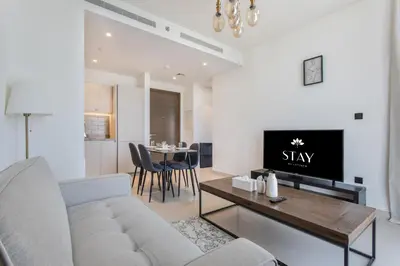 a living room with a couch and a table at STAY BY LATINEM Luxury 1BR Holiday Home CV B1311 near Burj Khalifa in Dubai