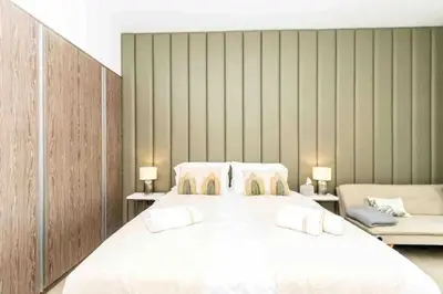 a bedroom with a large white bed and two chairs at Dubai Marina, LIV Residence, Luxury Studio Apartment in Dubai