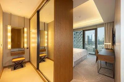a hotel room with a bed and a desk and a window at Stunning Address Opera 3Bedroom in Dubai