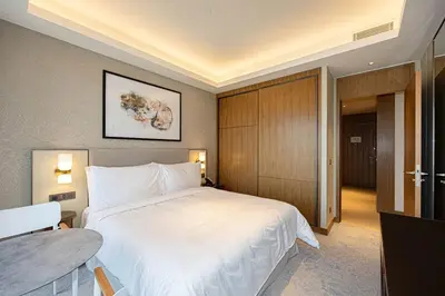 a bedroom with a large white bed and a table at Stunning Address Opera 3Bedroom in Dubai