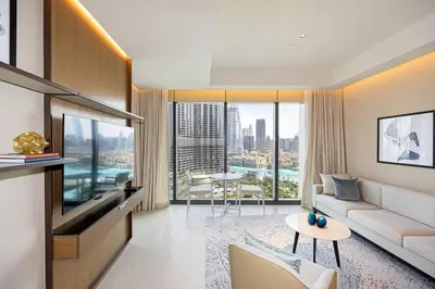 a living room with a couch and a tv and a table at Stunning Address Opera 3Bedroom in Dubai