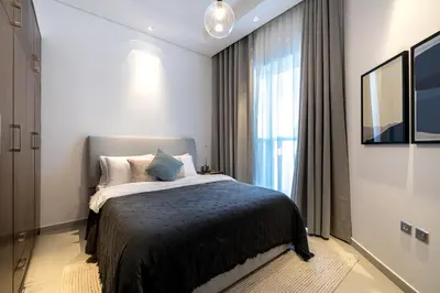 a bedroom with a bed and a large window at 2BR API 1000 Community View Jumeirah in Dubai