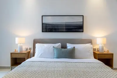 a bedroom with a bed with two nightstands and two lamps at 2BR API 1000 Community View Jumeirah in Dubai