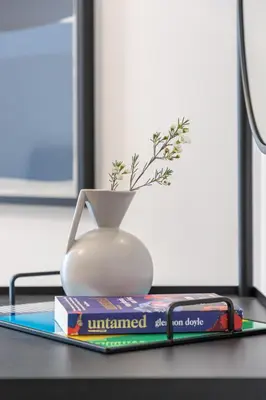 a book and a vase sitting on a desk at 2BR API 1000 Community View Jumeirah in Dubai