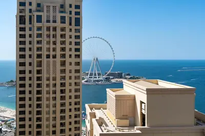 a view of two tall buildings and a ferris wheel at Breathtaking Scenery- JBR Walk- Beach Access in Dubai