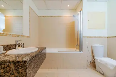 a bathroom with a sink and a tub and a toilet at Breathtaking Scenery- JBR Walk- Beach Access in Dubai