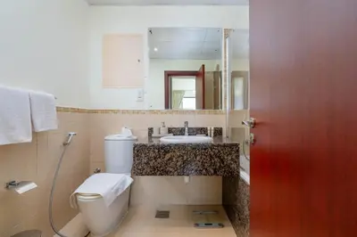a bathroom with a toilet and a sink and a mirror at Breathtaking Scenery- JBR Walk- Beach Access in Dubai