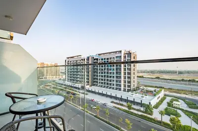 a balcony with a table and a view of a city at Chic Studio in Azizi Riviera 44, Al Merkadh by Deluxe Holiday Homes in Dubai