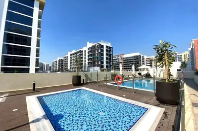 a swimming pool on top of a building with tall buildings at Chic Studio in Azizi Riviera 44, Al Merkadh by Deluxe Holiday Homes in Dubai