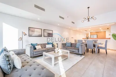 a living room with a couch and a table at Chic 2BR Apartment with Pool View in Marina Apartment 6, Palm Jumeirah by Deluxe Holiday Homes in Dubai