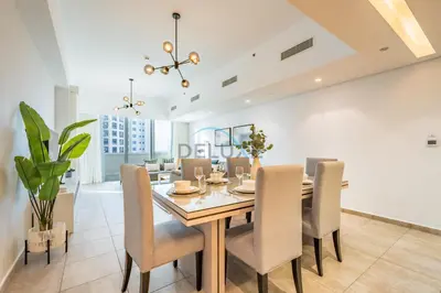 a dining room with a table and chairs at Chic 2BR Apartment with Pool View in Marina Apartment 6, Palm Jumeirah by Deluxe Holiday Homes in Dubai
