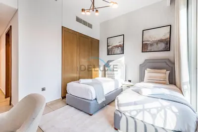 a bedroom with two beds and a chair at Chic 2BR Apartment with Pool View in Marina Apartment 6, Palm Jumeirah by Deluxe Holiday Homes in Dubai
