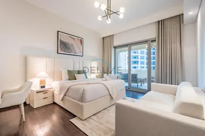 a white bedroom with a bed and a couch at Chic 2BR Apartment with Pool View in Marina Apartment 6, Palm Jumeirah by Deluxe Holiday Homes in Dubai