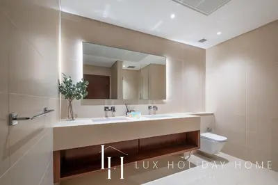 a bathroom with a sink and a toilet and a mirror at LUX The Marina Gate Sea View Suite in Dubai