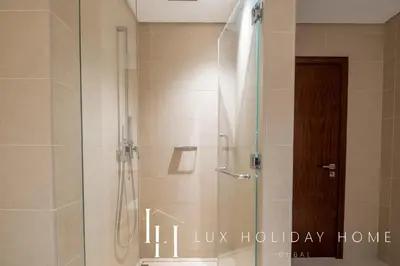 a shower with a glass door in a bathroom at LUX The Marina Gate Sea View Suite in Dubai