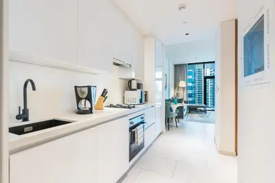 a white kitchen with a sink and a counter at Stunning Home Overlooking the Burj Khalifa in Dubai