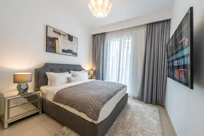 a bedroom with a bed and a large window at Luxuswohnung in Creek Harbour in Dubai