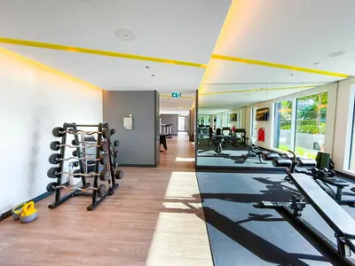 a gym with a row of tread machines and mirrors at Luxuswohnung in Creek Harbour in Dubai