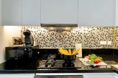 a kitchen with a stove and a plate of vegetables at New Cozy 1BR in the Heart of the City in Dubai