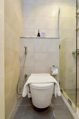 a white toilet in a bathroom with a shower at New Cozy 1BR in the Heart of the City in Dubai