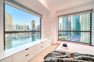 a bedroom with a large window with a view of the city at Elite 1 BR in JBR with Marina Views in Dubai