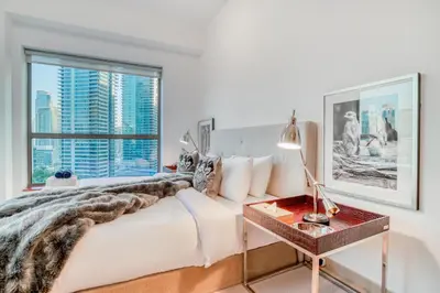 a bedroom with a bed with a view of a city at Elite 1 BR in JBR with Marina Views in Dubai