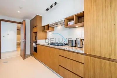 a kitchen with wooden cabinets and a counter top at Spacious 3BR Apartment with Assistant Room & Stunning Creek Views in The Dubai Creek Residences South Tower 1, Creek Harbour by Deluxe Holiday Homes in Dubai