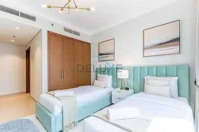 two beds in a bedroom with a blue headboard at Spacious 3BR Apartment with Assistant Room & Stunning Creek Views in The Dubai Creek Residences South Tower 1, Creek Harbour by Deluxe Holiday Homes in Dubai