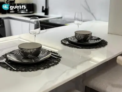 two plates and wine glasses on a kitchen counter at HiGuests - Luxury Apt in the Heart of JVC at Binghatti Nova in Dubai