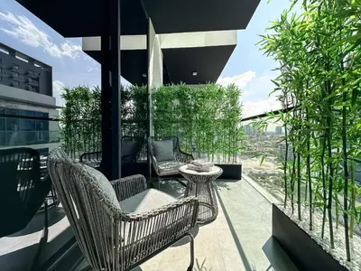 a balcony with chairs and a table on a building at Indulge in a Regal Retreat at JVC in Dubai