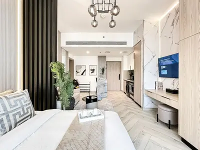 a living room with a white couch and a table at Indulge in a Regal Retreat at JVC in Dubai