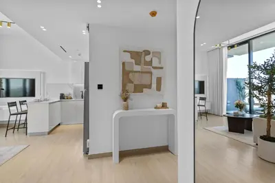 a living room with white walls and a white table at Elegant Living in 1 BDR at JVC with Top Amenities in Dubai