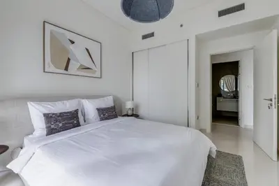 a white bedroom with a large white bed with pillows at Beach Vista - Private Beach & Palm Jumeirah Views in Dubai