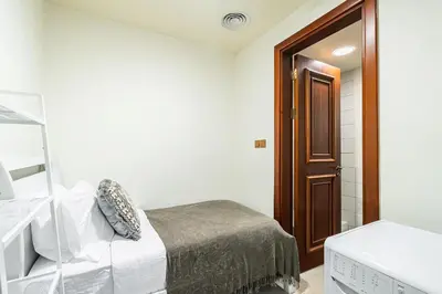 a bedroom with a bed and a sink and a mirror at Stylish 2 bedroom apartment with Maid Room I Fairmont South Residence I Palm Jumeirah in Dubai