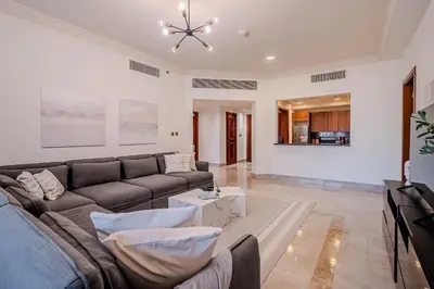 a living room with a couch and a table at Stylish 2 bedroom apartment with Maid Room I Fairmont South Residence I Palm Jumeirah in Dubai