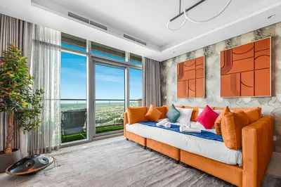 a living room with an orange couch with colorful pillows at 64th floor Skyline Pool with Burj Khalifa View in Paramount Hotel Midtown in Dubai