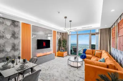 a living room with a couch and a tv at 64th floor Skyline Pool with Burj Khalifa View in Paramount Hotel Midtown in Dubai