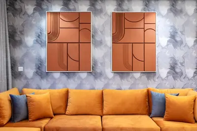 a living room with a couch and four paintings at 64th floor Skyline Pool with Burj Khalifa View in Paramount Hotel Midtown in Dubai