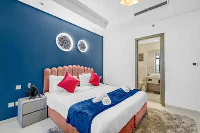 a bedroom with a large bed with a blue wall at 64th floor Skyline Pool with Burj Khalifa View in Paramount Hotel Midtown in Dubai