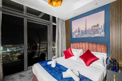 a bedroom with a bed with red pillows and a large window at 64th floor Skyline Pool with Burj Khalifa View in Paramount Hotel Midtown in Dubai