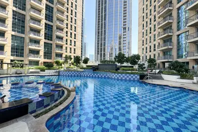 a large swimming pool in a city with tall buildings at Upscale 1 bedroom in the heart of Downtown in Dubai