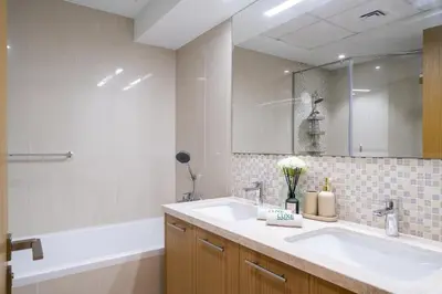 a bathroom with a sink and a tub and a mirror at Bellevue Towers by Luxe Living - Full Burj Khalifa View in Dubai
