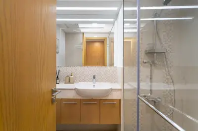 a bathroom with a white sink and a shower at Bellevue Towers by Luxe Living - Full Burj Khalifa View in Dubai