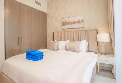 a bedroom with a large white bed with a blue bag on it at NewArabian Forte Downtown in Dubai